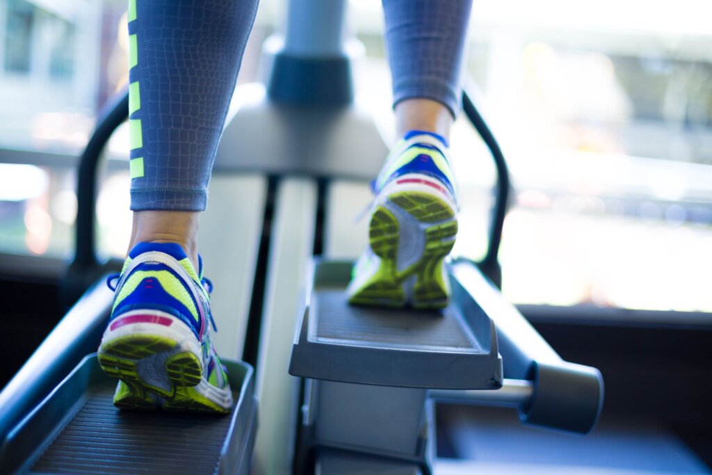 Close up of person wearing sneakers using elliptical