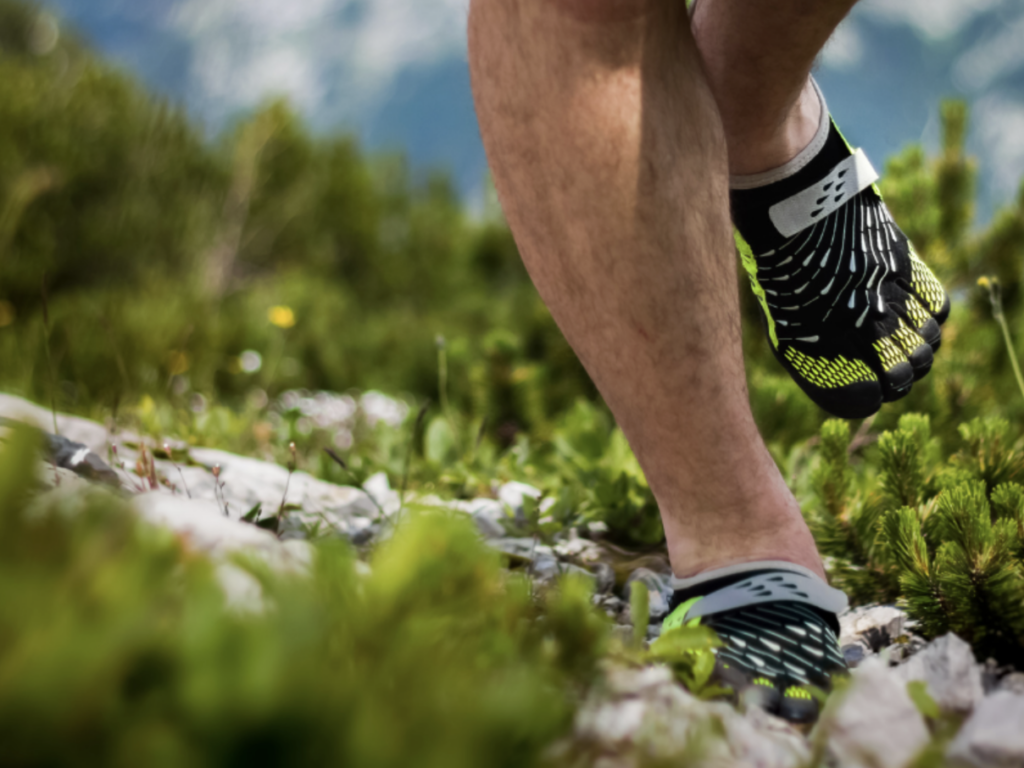 Man with toe shoes running outside