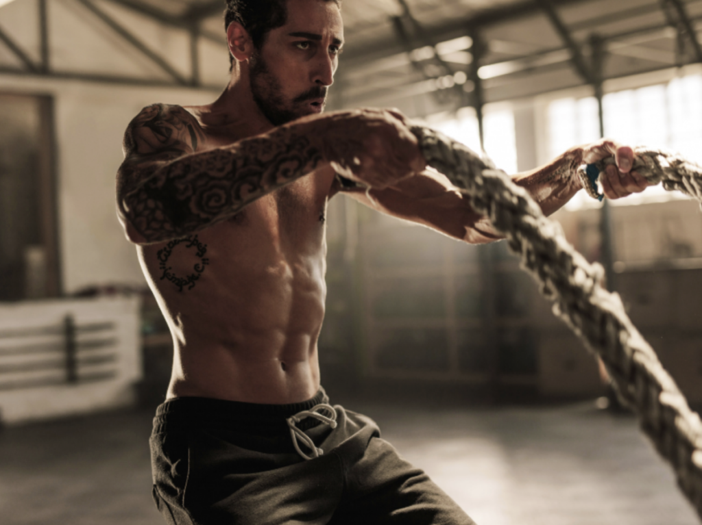 man exercising with battle ropes