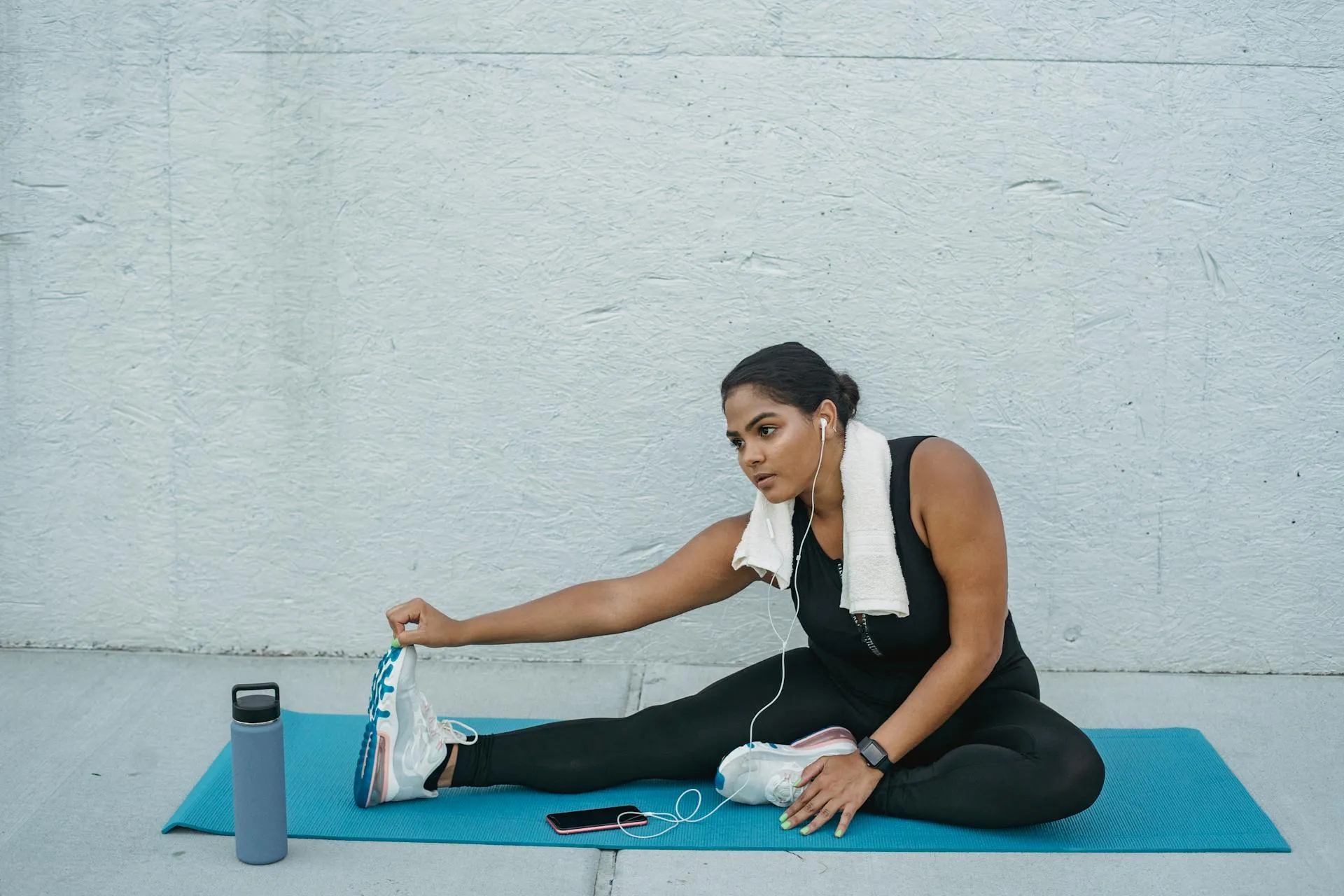 Brunette woman stretches on yoga mat